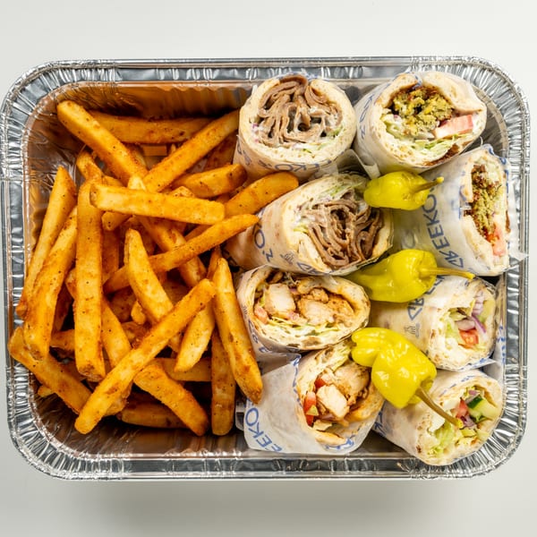 Greekos Grill & Cafe's foil tray with seasoned fries, gyros, and falafel wraps, garnished with peppers.